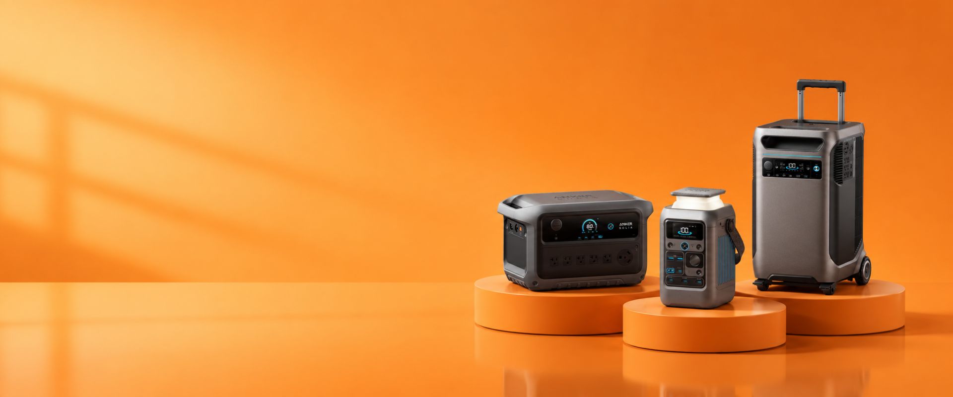 Three portable power stations on orange stands against an orange background